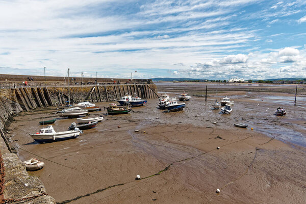 Minehead, Somerset, England, UK - 28 May 2025: Boats resting on the sand because the tide is out, in Minehead Harbour, Somerset, England, United Kingdom