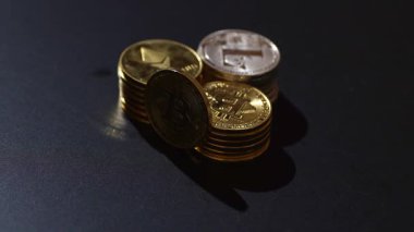 Siyah arka planda Bitcoin, Ethereum ve Litecoin 'i temsil eden metalik altın ve gümüş paralarla kripto para birimi. Kripto yatırımları, dijital zenginlik, engelleme eğilimleri ve ekonomik bozulma