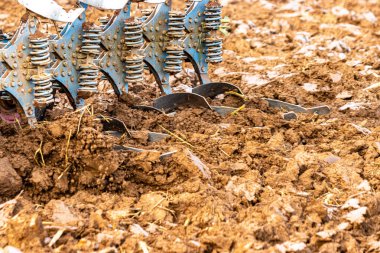 Büyük, modern bir traktör tarlayı sürerek toprağı ağır bir sabanla çevirir. Görüntü, güçlü tarım makinelerini, tarım arazilerini ve kırsal alandaki saha çalışmalarının başlangıcını gösteriyor..