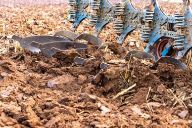 Büyük, modern bir traktör tarlayı sürerek toprağı ağır bir sabanla çevirir. Görüntü, güçlü tarım makinelerini, tarım arazilerini ve kırsal alandaki saha çalışmalarının başlangıcını gösteriyor..
