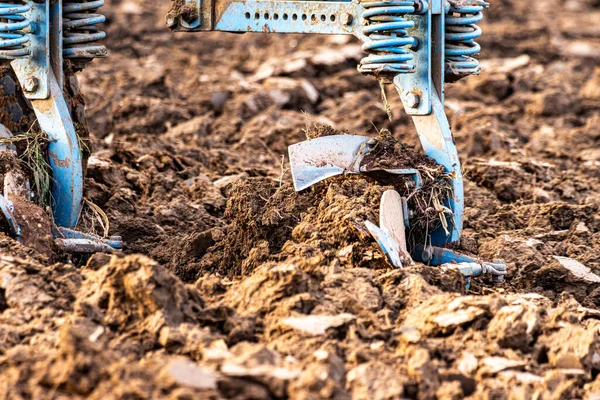 Büyük, modern bir traktör tarlayı sürerek toprağı ağır bir sabanla çevirir. Görüntü, güçlü tarım makinelerini, tarım arazilerini ve kırsal alandaki saha çalışmalarının başlangıcını gösteriyor..