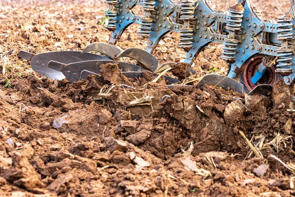 Büyük, modern bir traktör tarlayı sürerek toprağı ağır bir sabanla çevirir. Görüntü, güçlü tarım makinelerini, tarım arazilerini ve kırsal alandaki saha çalışmalarının başlangıcını gösteriyor..