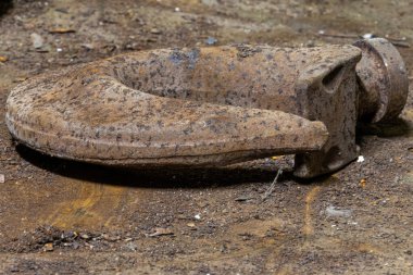 Ağır demir zincirler, kancalar, hava hortumları ve tedarik kabloları aktif bir kömür madeninin karanlık ve engebeli zemininde uzanıyor. Endüstriyel ekipmanlar ve loş yeraltı ortamı zor çalışma koşullarını vurguluyor.