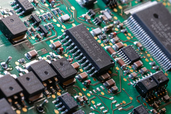 İşlemciler, rezistanslar, sayısız bakır izi ve renkli kablolar, karmaşık elektronik tasarım, hassas mühendislik ve modern teknoloji sistemlerinin bağlantısını gösteren yeşil devre kartları..