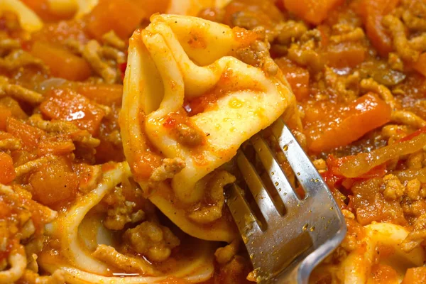 Çatallı taze tortellini, zengin İtalyan eti ve sebze sosuyla kaplı. Sıcak, renkli yemekler otantik İtalyan mutfağını, taze malzemeleri ve lezzetli ev usulü yemekleri ön plana çıkarıyor..