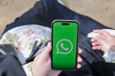 Ekranda uygulaması olan akıllı bir telefonu tutan el.