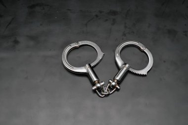 Siyah arka planda tırtıklı kilit mekanizması olan profesyonel metalik yüksek güvenlik kelepçeleri..