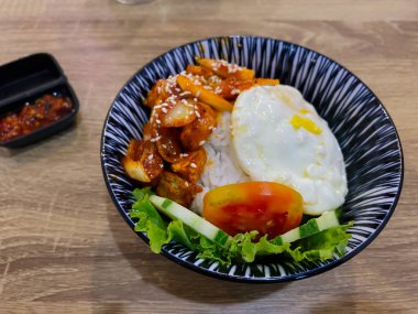 Siyah tabakta kızarmış pilav ve sebze.