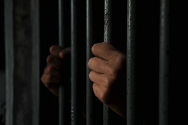 Adamın elleri kafeste dikenli tel tutuyor..