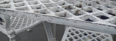 Delikleri olan beyaz demir bir masanın yakın çekimi. Doku fotoğrafçılığı kapat