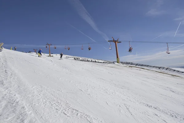 Pista de esquí con telesilla en el fondo y cielo azul — Foto de Stock