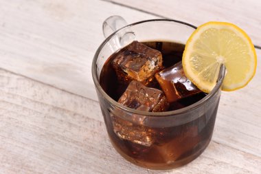 Cola İçecek beyaz rustik ahşap zemin üzerinde buz küp ve limon dilimi ile