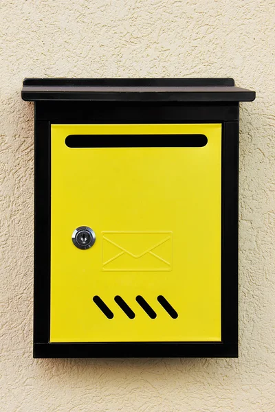 Gele brievenbus op de muur. — Stockfoto