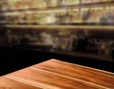 Basit, doğal renkli ahşap bir masa, bulanık bir bar tezgahı olan sıcak bir his verir..