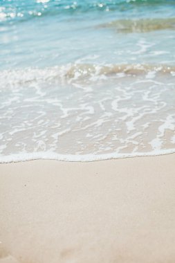 Kumlu sahilde yumuşak mavi okyanus dalgaları. Arkaplan.