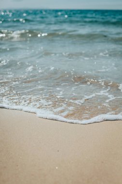 Kumlu sahilde yumuşak mavi okyanus dalgaları. Arkaplan.