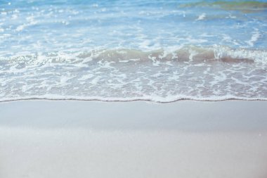 Kumlu sahilde yumuşak mavi okyanus dalgaları. Arkaplan.