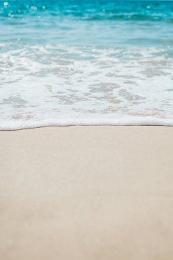 Kumlu sahilde yumuşak mavi okyanus dalgaları. Arkaplan.