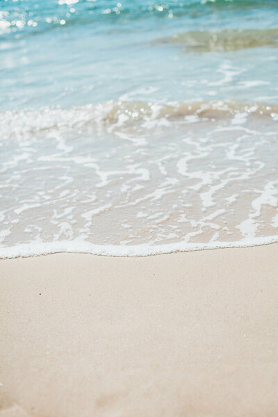 Soft blue ocean wave on sandy beach. Background.