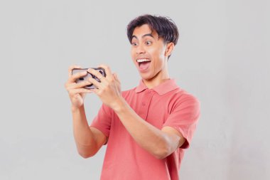 Mutlu Asyalı adam akıllı telefon kullanıyor ve selfie çekiyor.