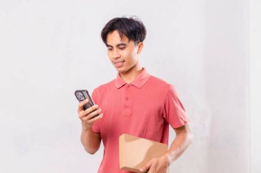 Genç yakışıklı Asyalı adam cep telefonu tutuyor.