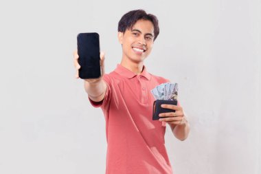 Gülümseyen Asyalı adam içi para dolu cüzdanı tutarken boş cep telefonu ekranı görüntüsü çiziyor.