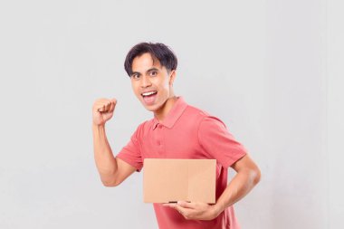 Karton paket kutusu tutan neşeli Asyalı adam hızlı teslimat konsepti için arka planda izole edilmiş bir jest gösteriyor..