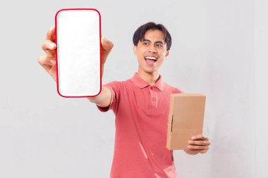 Şaşırmış genç, Asyalı bir adam boş akıllı telefon ekran maketi gösteriyor ve paket kutusunu dış dünya dağıtım promosyonu için izole edilmiş halde tutuyor..