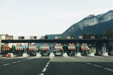 İtalya, 6 Eylül 2025, İtalyan otoyolu üzerinde birden fazla şerit ve araçla geçen bir tren istasyonu. Arka planda dağ manzarası var. İtalya 'da ücretli yol altyapısı. Yüksek kalite fotoğraf