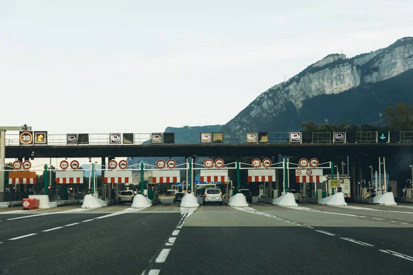 İtalya, 6 Eylül 2025, İtalyan otoyolu üzerinde birden fazla şerit ve araçla geçen bir tren istasyonu. Arka planda dağ manzarası var. İtalya 'da ücretli yol altyapısı. Yüksek kalite fotoğraf