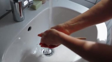 Çevre dostu sabah rutini. Beyaz lavabonun üzerindeki tahta bir diş fırçasına diş macunu sürerken ellerinizi kapatın. Sürdürülebilir diş bakımı, temiz başlangıç, doğal hijyen, sıfır atık banyo. Yüksek kaliteli FullHD görüntüler