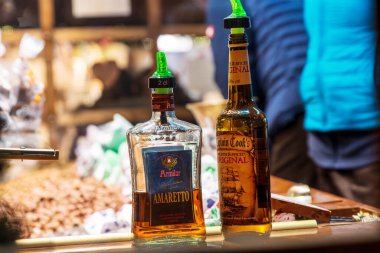 Wuerzburg, Almanya, 22 Aralık 2024. İki şişe Armiral Amaretto ve Kaptan Cook yılbaşı pazarında ahşap tezgahta likör içtiler. Seçici odak