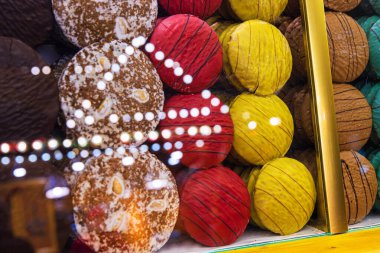 Canlı el yapımı zencefilli çörek mermileri çeşitli renklerde ve dokularda, neşeli ışık yansımaları olan cam bir tezgahın arkasında düzenlenmiştir. Seçici odak.