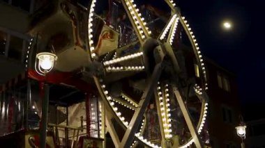 Wuerzburg, Almanya, 20 Aralık 2024. Açık hava fuarında ya da noel pazarında gece çalışan parlak bir klasik dönme dolap. Festival fuarında gözlem tekeri gezisi