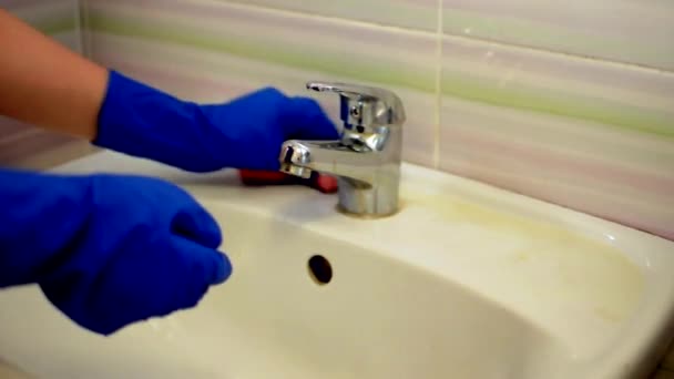 Girl in blue gloves washes the sink, cleaning the bathroom. Housekeeper as a cleaner at the sink. Brush up Toilet for cleanliness and hygiene. cleaning the sink. Cleaning service concept — Stock Video