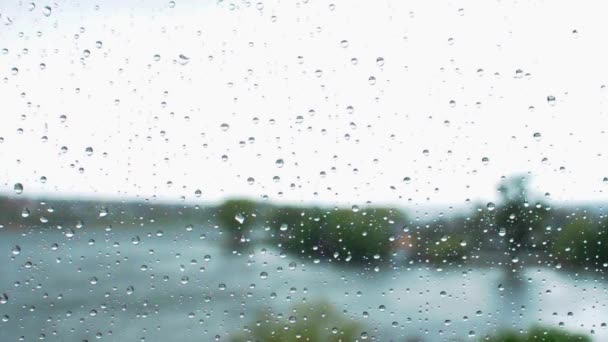 Gotas de lluvia corren por el cristal de la ventana. Cortinas de otoño con fuertes lluvias. Clima frío gris fuera de la ventana. — Vídeo de stock