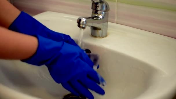 Ragazza in guanti blu lava il lavandino, la pulizia del bagno. Fa la domestica come addetta alle pulizie al lavandino. Spazzolare servizi igienici per la pulizia e l'igiene. pulire il lavandino. concetto di servizio di pulizia — Video Stock