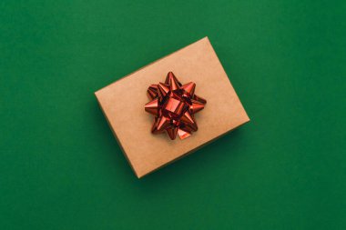 Noel sınırında hediye paketi ve yeşil arka planda kırmızı fiyonk var. Kış tatili Yeni yılınız kutlu olsun. Mesaj için yer. Üst manzara, düz yatış. Noel zamanı. Şablon, pankart.