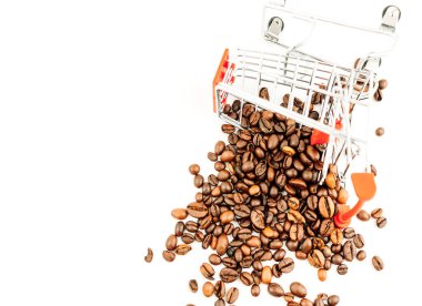 Beyaz arka planda kahve çekirdekleri olan bir alışveriş arabası. Fasulye arabası devrildi ve kahveyi masaya döktü. Üst manzara, izole et. Kahve endüstrisi kavramı.