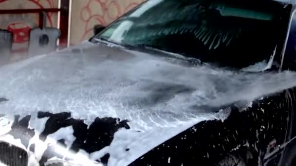 Het proces van het wassen van een BMW business class auto, spoelen het schuim uit een waterpistool. Concept van auto-service en wasmachine — Stockvideo