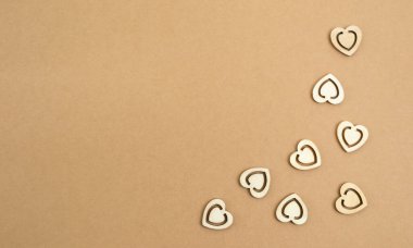 Pastel işçiliğin arka planında tahta kalpler. Ahşap kesim şekilli soyut bir arkaplan. Sevgililer günü, anneler günü, doğum günü kartları, davetiyeler. Boşluğu kopyala.