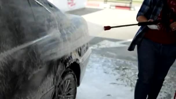 Agosto de 2020, Vinnytsia: Proceso de lavado para BMW completamente cubierto con espuma blanca y spray de una pistola de agua. Aplicación de espuma en el exterior del coche brillante. Concepto de servicio automático y lavadora — Vídeo de stock