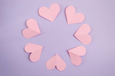 Sevgililer Günü geçmişi. Pembe kalpler, mor renkli bir arka planda daire şeklinde dizilmiş. Sevgililer Günü konsepti. Kartpostalların planı ve tebrikler. Düz konum, üst görünüm, kopyalama alanı