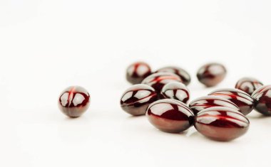 Kırmızı kapsüller, haplar, beyaz arka planda ilaçlar. Eczane, insanlar ve sağlık konsepti. Vitaminler ve besin takviyeleri. Boşluğu kopyala.