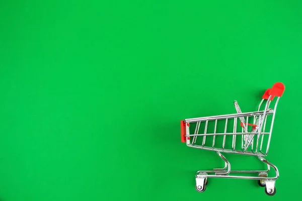 Rojo Pequeño Carrito Compras Mentiras Fondo Verde Compras Línea Concepto —  Fotos de Stock