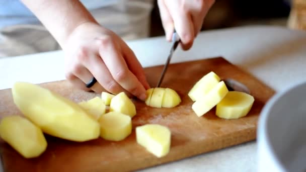 Cubetti di chef sbucciato patate su un tagliere di legno con un coltello affilato. Concetto di cucina casalinga da prodotti naturali. — Video Stock