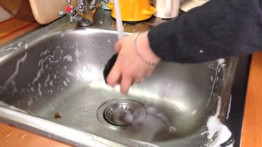 Kadınların elleri mutfak lavabosunu pislikten temizler. Kız köpük temizleyiciyi duruluyor. Ev işleri işte. Mutfağı ve günlük hayatı temizleme kavramı.