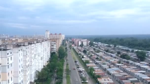 Timelapse un soir d'été avant un orage, les voitures roulent le long d'une rue de la ville dans un quartier résidentiel. Grands bâtiments résidentiels d'un côté de la route et garages de l'autre. — Video