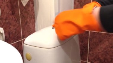 Bir ev hanımı klozeti bir bezle siler. Tuvalet temizliği ve yıkama. Ev temizliği hizmeti konsepti. Genel temizlik yapıyor. Ev temizliği hizmeti konsepti. Yakın plan..