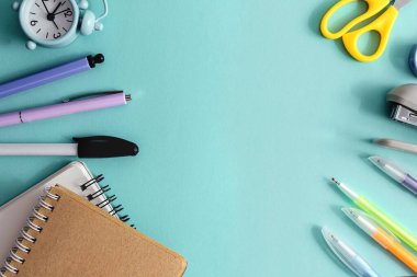 Okulun yaratıcı üst görüşüne dönüş konsepti. Açık mavi kağıt arka planda okul ve ofis malzemeleri. Boşluğu kopyala, metin veya tasarım için şablon.